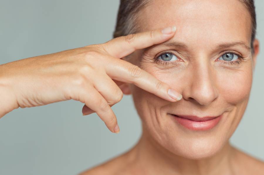 Smiling Senior Woman with Victory Sign Over One Eye